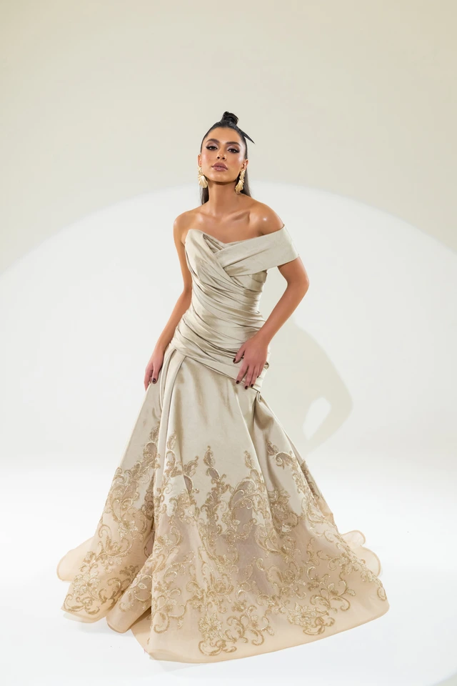 Champagne-toned off-the-shoulder gown with a fitted bodice and flared, patterned skirt., photo 1