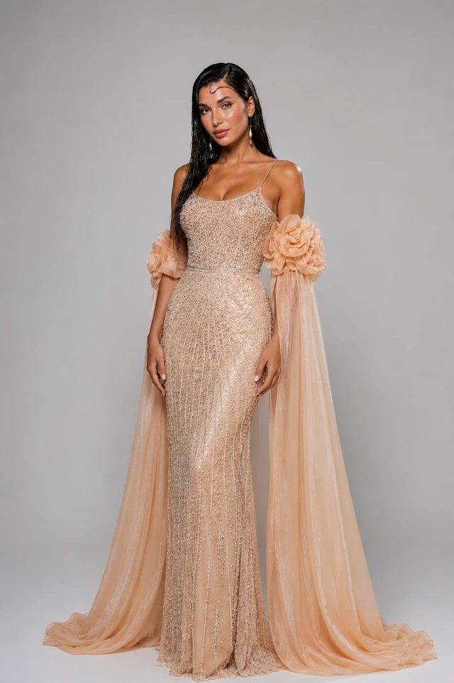Champagne-toned gown with sheer, decorated sleeves and a long, flowing skirt., photo 1