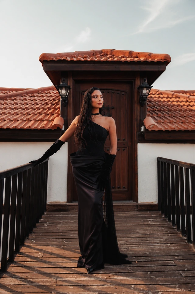 Black asymmetric gown with a fitted waist and a floor-length skirt., photo 1